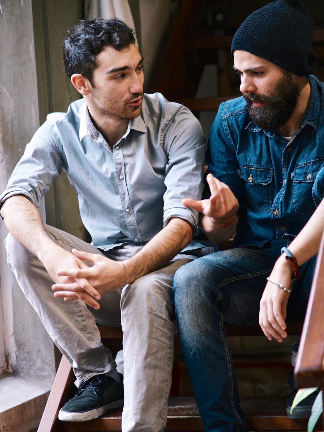 Two professionals deep in candid conversation on a stairwell at an event