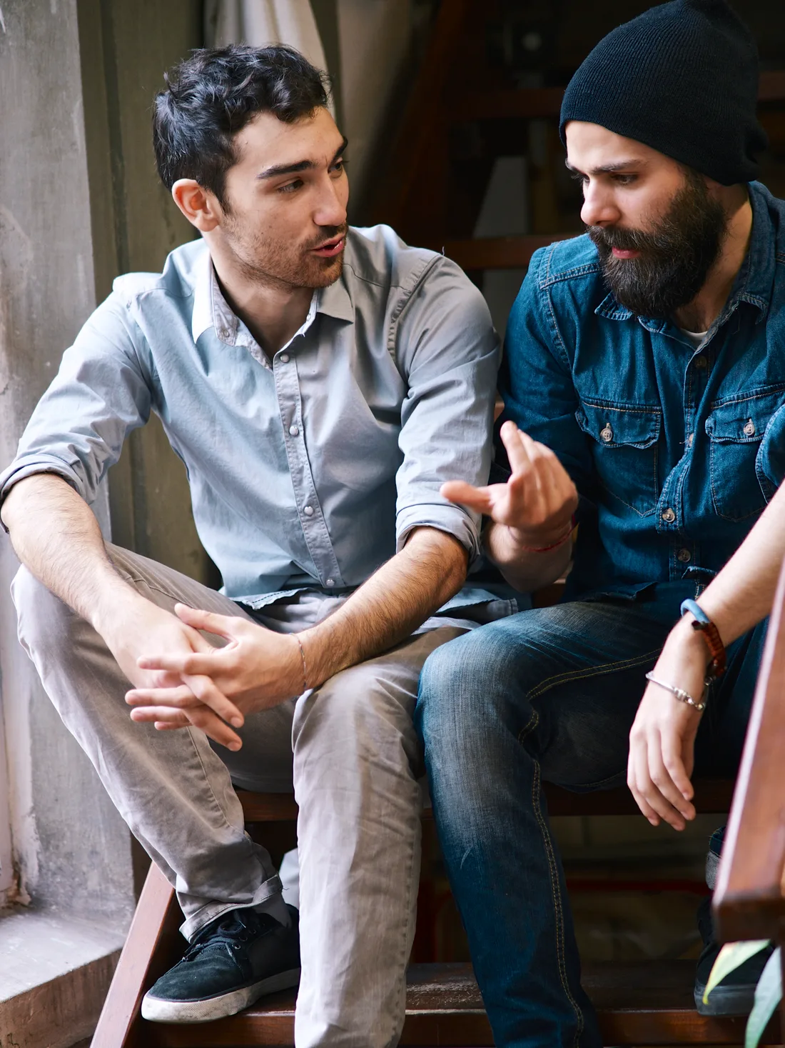 Two professionals deep in candid conversation on a stairwell at an event